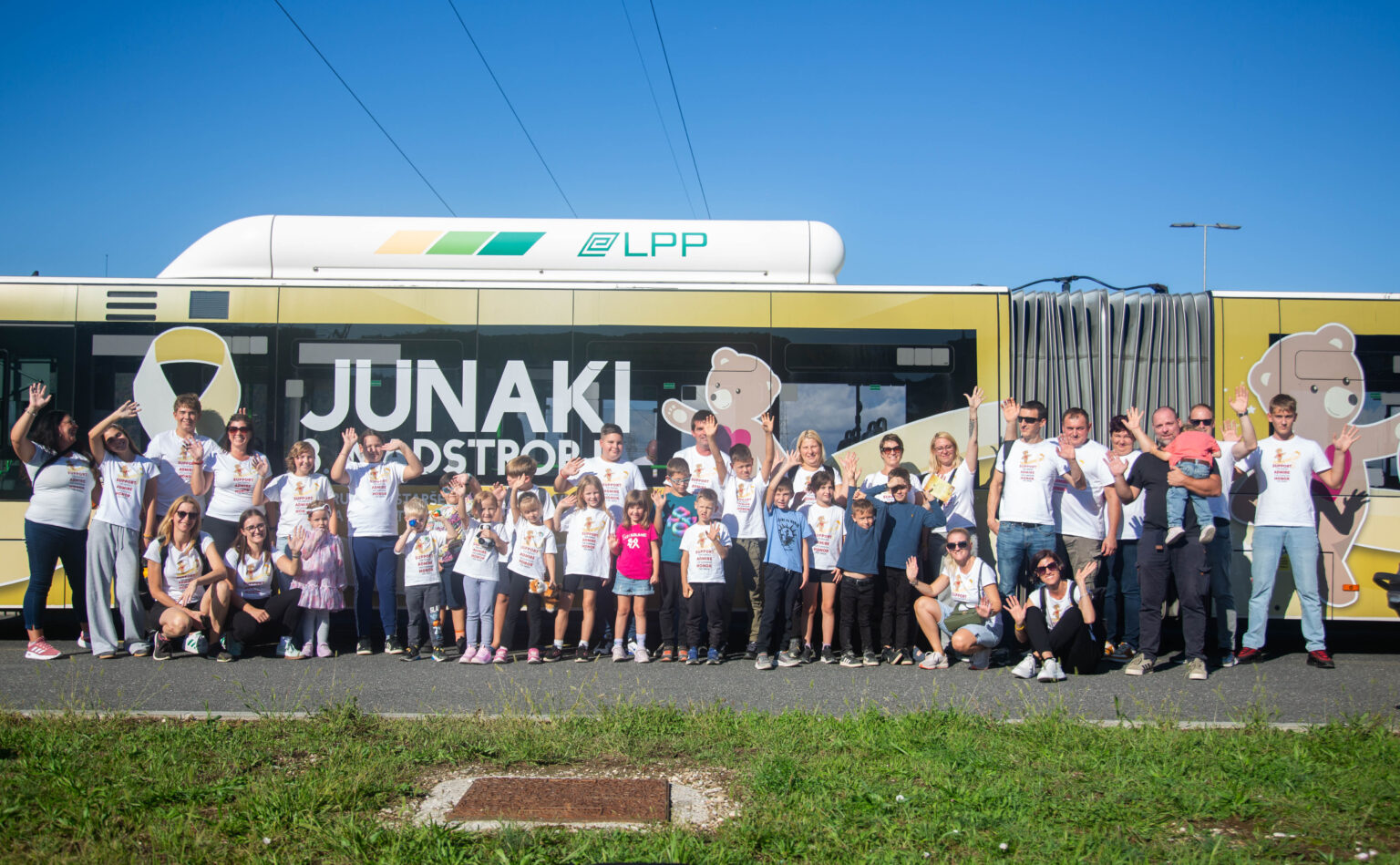 Junaki 3. nadstropja pred polepljenim zlatim avtobusom v Ljubljani